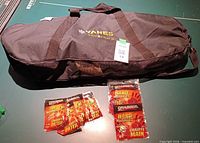 Carry bag with Yanes logo and five hand-warmer packets on tabletop