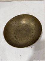 Top view of brass bowl showing engraved characters and foliage