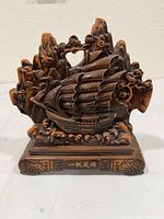 Front view showing detailed ship, waves, mountains, trees, and inscription