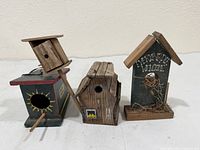 Three wooden birdhouses front view