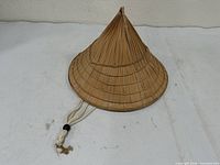 Full exterior view of bamboo conical hat with chin cord
