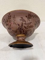 Side view showing pedestal foot, floral pattern, gold tone accents
