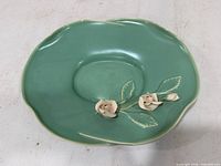 Top view showing green dish, shape and floral appliqués