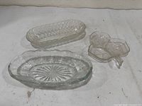 Three clear pressed glass dishes shown top view