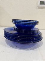 Stacked view showing all cobalt blue swirl dinner and salad plates plus bowl