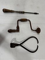 All three tools laid out: brace drill, straight drill, caliper.