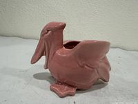 Side view of pink ceramic pelican planter