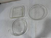 Overview of three clear glass dishes: square, round straight-sided, pie plate