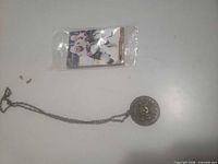 Pendant necklace and sealed hockey card pack side by side