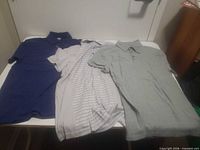 Three polo shirts laid flat showing colors and styles