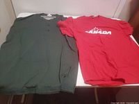 Red CANADA T-shirt and green henley laid flat