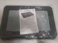 Top view of sealed Action Board with instruction manual placed on surface