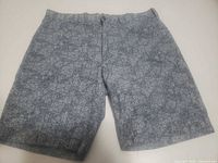 Front view of blue-gray floral shorts laid flat