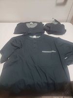 Full view of scrub top, pants and jacket laid out