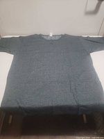 Full view of teal long-sleeve henley laid flat
