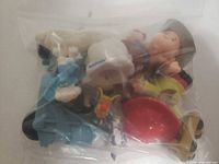 Bag showing assorted figures including bald child, blue creature, soccer player