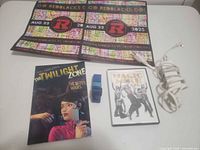 Lot overview showing book, DVD, posters, charger and strap