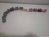 Curved line of 12 mini plastic trains showing full lot
