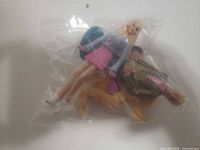 Both dolls and horse accessories inside clear bag