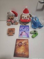 All items laid out: three plushes, two books, koozie, two silicone holders