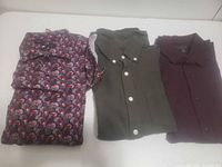Three folded shirts showing colors and patterns