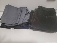 Two stacks of folded men’s pants showing colours and fabrics