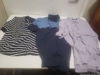 Three shirts laid flat showing fronts and colours