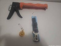 All three items together: caulking gun, pet seatbelt strap, badge reel
