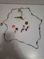 Entire lot showing bird ornament, beaded strand and loose Halloween charms