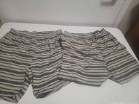 Pair of green and tan striped boxer shorts laid flat