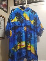 Front view of blue tropical print Rima Hawaiian shirt on hanger