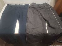 Two pairs of pants laid out side by side