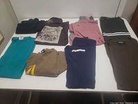 All eight folded clothing items displayed on table