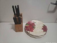 Knife block with knives and stack of plates side by side