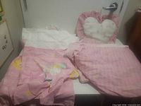 Entire bedding set laid on table showing comforter, pillowcase, and heart pillow