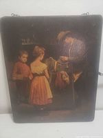 Front view of wooden plaque showing printed scene and overall condition