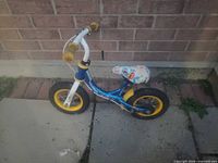 Full side view of WeeRide balance bike against brick wall