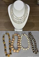 All five necklaces laid out with crystal piece on stand