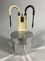 Front view of aluminium espresso maker showing twin dispensing arms and base
