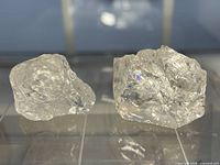 Both clear quartz crystals side-by-side, showing size difference and clarity