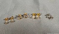 All four pairs of stud earrings lined up on fabric