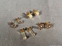 Group shot of all four pairs of gold stud earrings