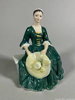 Front view of figurine showing gown, hat and facial features