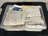Top view of plastic bin filled with folded assorted linens