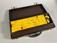 Open carrying case showing neatly stacked yellow Bakelite mahjong tiles