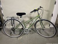 Full side view of green Jamis Commuter 1 bicycle showing frame, wheels, handlebars, saddle