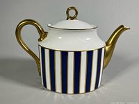 Profile of teapot showing striped body and gold handle