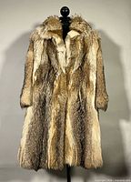 Full front view of vintage raccoon fur coat on stand