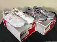 Grey and white/pink New Balance shoes on boxes