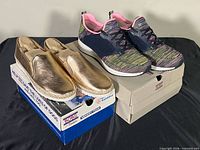 Both pairs of shoes on their boxes